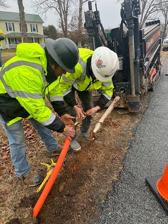 Telecom Construction: 13 Exciting Details About Emerging Technology A National crew unhooks conduit from the bore head of a horizontal directional drill in preparation to bury fiber optic cable.