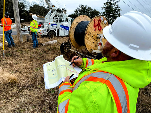 Fiber Optic Boom: Transformative Trends Lighting Up the Future National OnDemand Crew inspecting fiber optic on a pole.